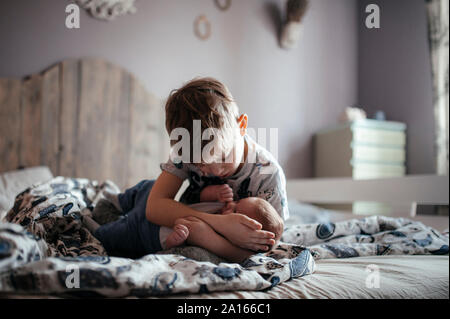 Garçon plus âgé avec son petit frère dans la chambre à coucher Banque D'Images