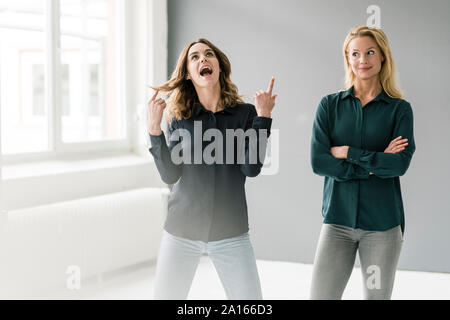 Deux jeunes femmes debout dans cette chambre lumineuse, imaginant succès Banque D'Images