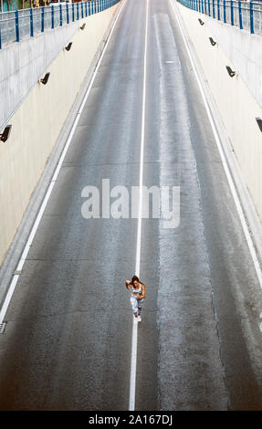 Vue de dessus de sporty young woman running on a street Banque D'Images