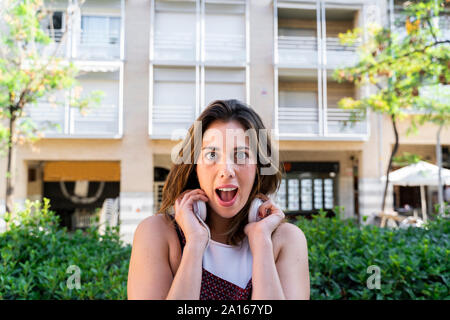 Portrait of young woman listening music Banque D'Images