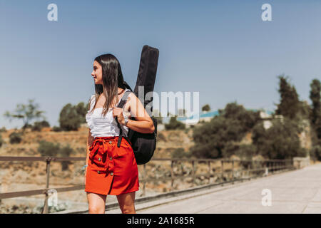 Jeune femme jouant de la guitare, la marche sur le pont Banque D'Images