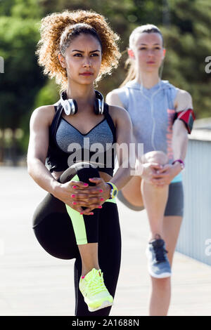 Deux jeunes femmes sportive faisant l'exercice d'étirement Banque D'Images