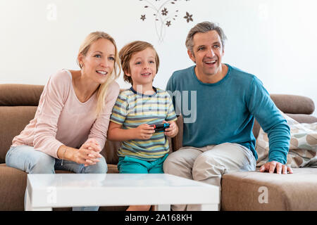 Les parents heureux avec son playing video game sur la table à la maison Banque D'Images