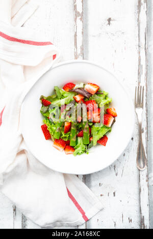 Directement au-dessus de la salade de tomates au milieu de fourchette et serviette de table en bois Banque D'Images