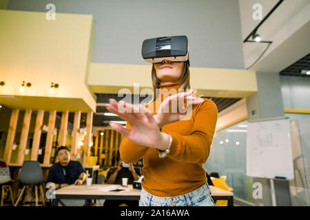 Femme en touchant des objets casque VR en réalité virtuelle. Girl en interaction avec la visualisation 3d. Il moderne produit test sur simulateur numérique concept Banque D'Images