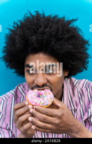 Young man eating donut Banque D'Images