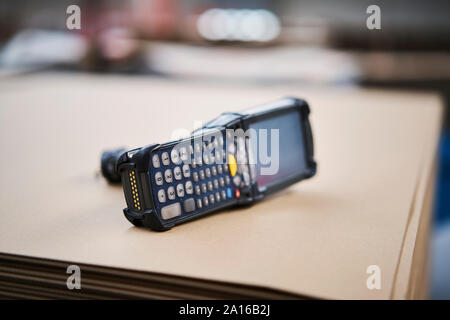 Scanner de codes-barres se trouvant sur carton en usine Banque D'Images