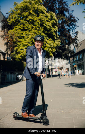 Man avec l'e-scooter dans la ville Banque D'Images