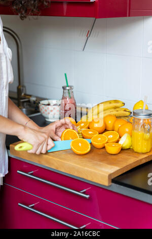 Close-up of woman in kitchen découpage des oranges pour un jus Banque D'Images