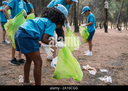Groupe d'enfants bénévolat collecte des ordures dans un parc Banque D'Images