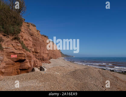 La célèbre côte jurassique falaises rouges à Sidmouth, Devon, Angleterre. À l'Est de la plage de Sidmouth avec mise en garde contre les risques de glissements de terrain. Banque D'Images