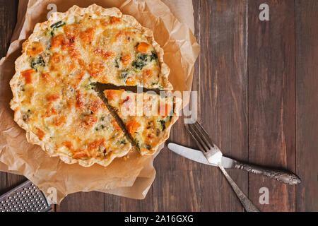 Quiche maison tarte ou avec des légumes, épinards et fromage sur la table en bois rustique Banque D'Images