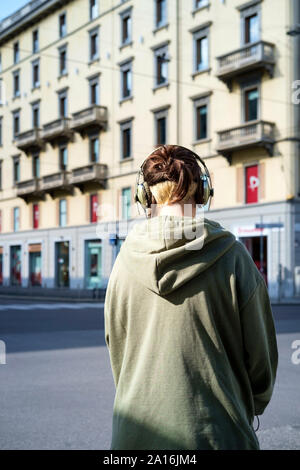 Fille dans la rue de Milan portant des écouteurs Banque D'Images