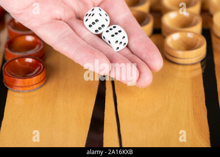 Dans le domaine des dés jeu palm. Un homme est sur le point de jeter sur un dés de backgammon. Close up. Banque D'Images