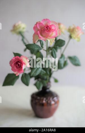 Bouquet de roses jaunes rose pâle dans un vase en céramique sur une table, side view Banque D'Images