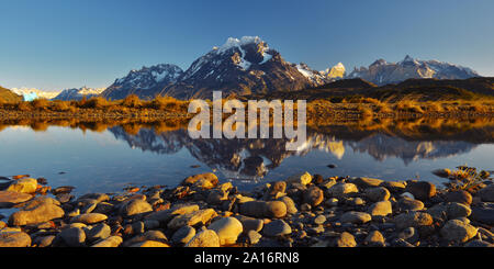 Vue panoramique de réflexion Torres del Paine et Cuernos pics dans lac Grey avec un iceberg au lever du soleil, parc national Torres del Paine, en Patagonie, au Chili. Banque D'Images