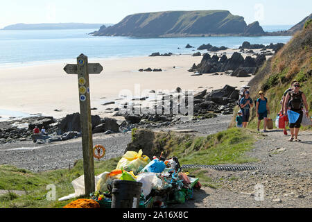 Collecte des déchets et de plastique provenant de la nettoyage de plage au château de Manorbier et famille marche sur Galles Pembrokeshire CoastPath UK KATHY DEWITT Banque D'Images