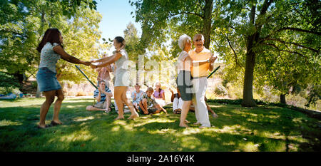 Grande famille danser dans un parc. Banque D'Images