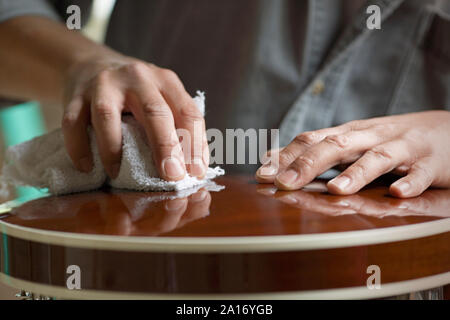 Mains d'un homme un essuyage de la surface vernie. Banque D'Images