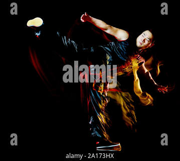 La boxe Chinoise de Wushu Kung Fu Hung Gar fighter homme isolé isolé sur fond noir avec effet peinture lumière vitesse de flou Banque D'Images