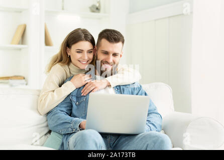 Jeune couple de passer du temps à la maison, man using laptop Banque D'Images