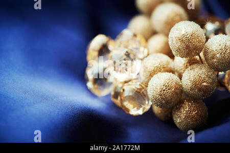 Close up of golden noël décor sur satin bleu foncé Banque D'Images