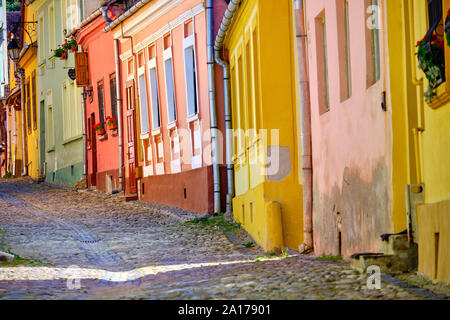 Un côté de la rue des façades colorées préservé avec cobblestone street montée à la citadelle de Sighisoara, Roumanie. Sighisoara, Roumanie - Banque D'Images
