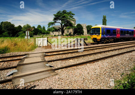 Un premier grand train de l'Ouest dans une voie de garage en face de l'église St Mary, Great Bedwyn, Wiltshire. vu de la passerelle sur un sentier public crossing. Banque D'Images