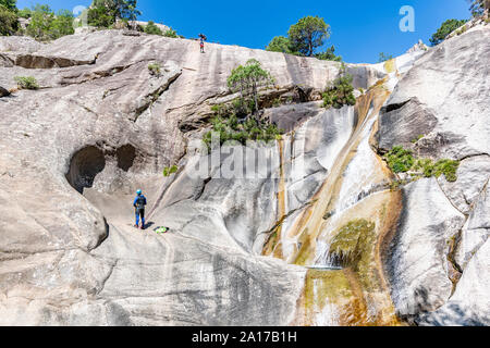 Les gens à côté d'une cascade de canyoning le célèbre Canyon Purcaraccia à Bavella en été, Corse, France Banque D'Images