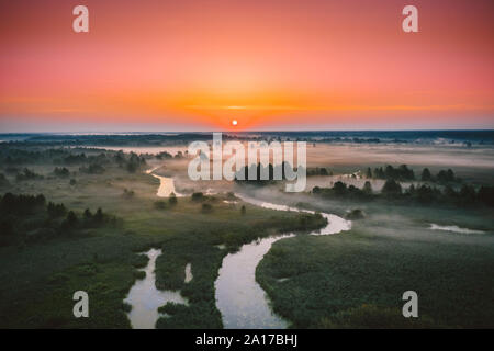 Vue aérienne Pré Vert et la rivière dans le paysage brumeux Matin brumeux. Vue de dessus de la belle nature de l'attitude européenne élevée en été. Drone Banque D'Images