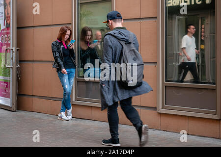 Moscou, Russie - le 14 septembre 2019 : les jeunes en demi-saison, vêtements fume dans la rue et regarde l'écran de son smartphone. Les jeunes, une Banque D'Images