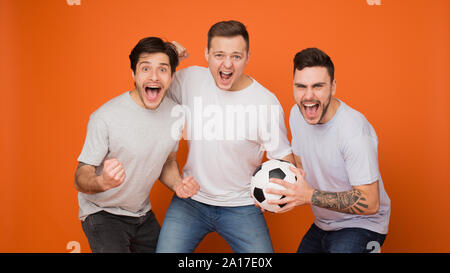 But ! Les fans de football holding soccer ball et crier Banque D'Images