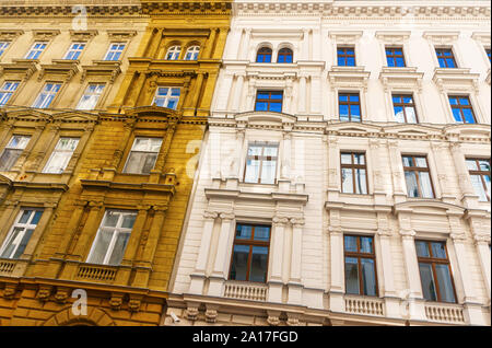 Blanc et monumentale façade de couleur ocre jaune dans le style architectural néo-classique avec des fenêtres ornementées. Budapest, Hongrie. Banque D'Images