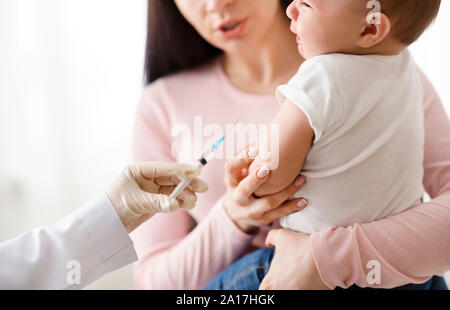 Doctor giving injection intramusculaire à petit bébé Banque D'Images