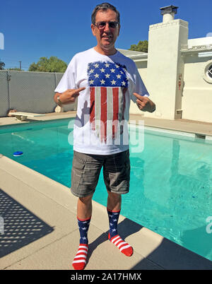 Le port d'un mâle adulte patriotique stars and stripes t-shirt et chaussettes debout près d'une piscine à Tucson AZ Banque D'Images