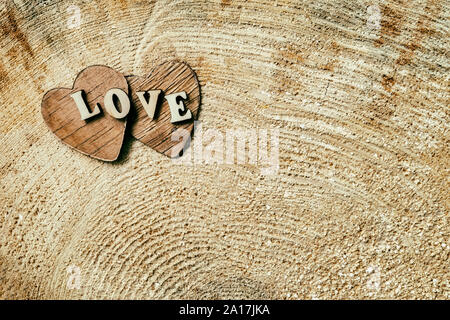 Mot amour de lettres en bois sur deux coeurs en bois, sur la surface en bois de coupe, texture grunge , fond Banque D'Images
