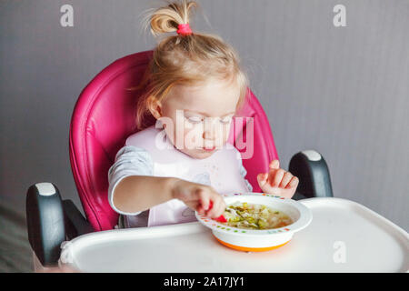 Infant Baby Avec Visage Sale Soupe Manger Elle Meme Avec Une Cuillere Cute Little Girl Sitting En Haute Chaise De Bebe Dans La Cuisine A La Maison Concept D Enfance Famille Maternite Photo Stock