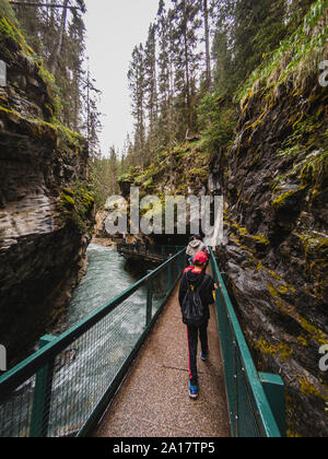 Les gens qui marchent sur les podiums de métal aux côtés de l'écoulement de l'eau dans la région de canyon. Banque D'Images