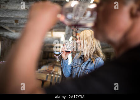 Jolie femme blonde dégustation des vins à partir de fûts de chêne. Banque D'Images