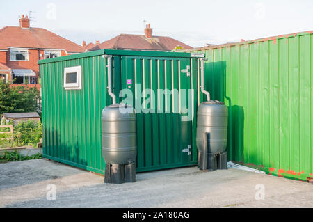 Récipient en métal toilettes unité sur site avec de l'eau allotissement butts pour recueillir de l'eau pour le rinçage et pour l'hiver quand l'eau s'est éteint Banque D'Images