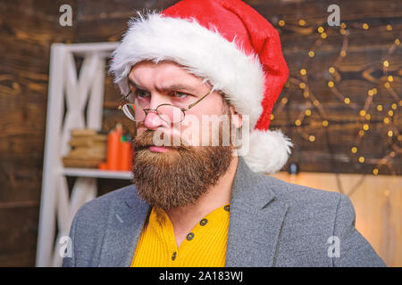 Santa Claus caractéristiques concept. Barbu homme homme mûr visage sérieux porter santa hat avec la fourrure et lunettes à l'ancienne close up. Homme sérieux moustache barbe jouant santa rôle. La tradition de Noël. Banque D'Images