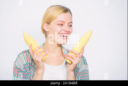 La production de maïs. L'agriculture, farmer girl avec le maïs. Happy woman eating corn. la récolte de légumes. dents saines. L'agriculture et de la culture. récolte de maïs. vitamine et suivre un régime alimentaire. La culture du maïs. Banque D'Images