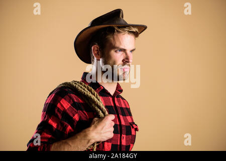 Prêt à rouler. homme Chemise à carreaux sur ranch. wild west rodeo. man in hat. et de l'ouest portrait. cowboy avec lasso de corde. Western. L'homme de style vintage. Wild West cow-boy rétro. Banque D'Images