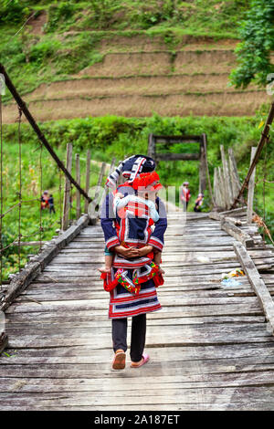 Minorité ethnique Dao rouge mère et bébé (DAO), sur un petit pont suspendu de l'Hoang Su Phi, Ha Giang province, dans le nord-ouest montagneux par Banque D'Images