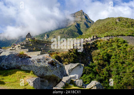 Machu Picchu ancienne ville ruines lever de soleil, Vallée sacrée des Incas, Pérou. Touristes descendant les terrasses de la ville, les ruines du Machu Pichu, tôt le matin. Banque D'Images