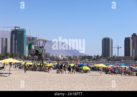 IQUIQUE, CHILI - 23 janvier 2015 : tour de sauveteur, de parasols et de nombreux visiteurs sur Cavancha Beach le 23 janvier 2015 à Iquique, Chili Banque D'Images