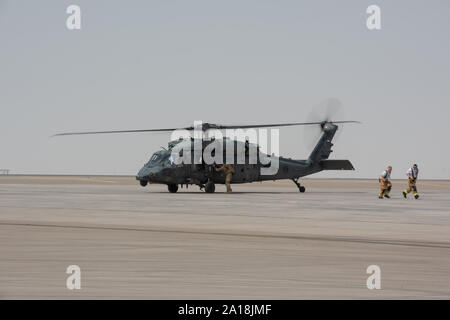 380e escadre expéditionnaire aérienne Les pompiers retour loin d'un Emirati UH-60 Black Hawk après transfert d'un patient simulé au cours d'un grand exercice de premiers secours le 24 septembre 2019, à la base aérienne d'Al Dhafra, aux Émirats arabes unis. L'exercice a contribué à favoriser le partenariat avec l'United Arab Emirates Air Force Commande conjointe de l'Aviation à la pratique d'un scénario d'évacuation sanitaire aérienne par hélicoptère. (U.S. Photo de l'Armée de l'air par le sergent. Chris Thornbury) Banque D'Images