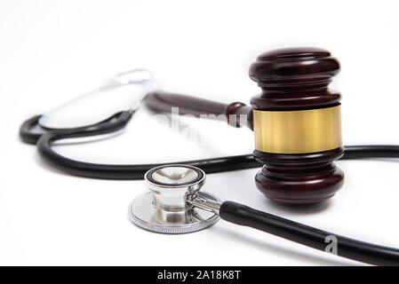 Un juge en bois marteau et stéthoscope isolé sur fond blanc. Litige médical concept. Banque D'Images