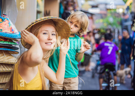 Mère et fils voyageurs de choisir des souvenirs dans le marché à Ubud à Bali, Indonésie Banque D'Images