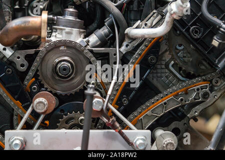 Gros plan sur un moteur démonté avec une vue sur le mécanisme de distribution de gaz, chaîne, pignons et tendeurs pour la réparation et la restauration après un bre Banque D'Images